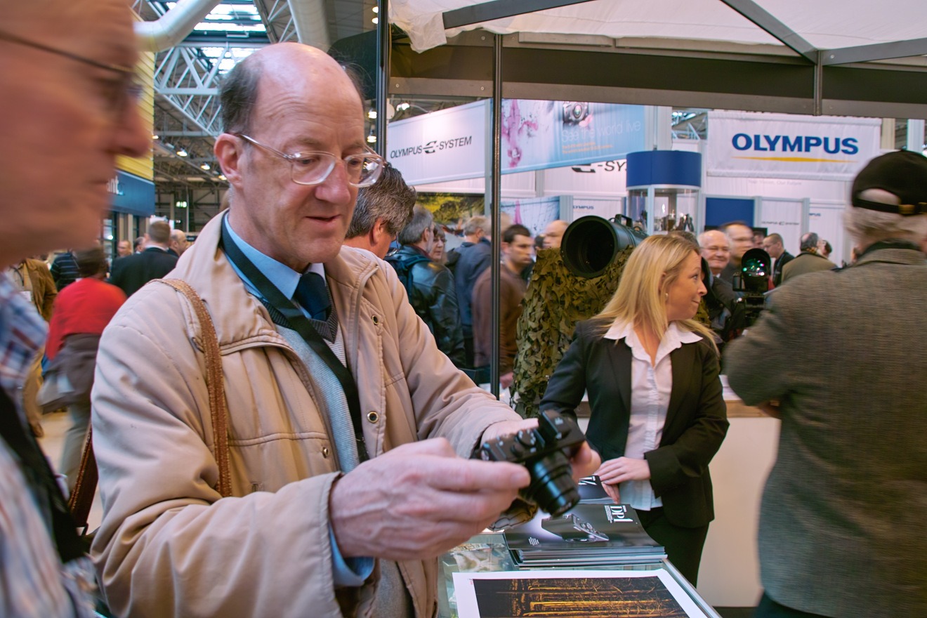 Photographers looking at the DP-1 during Focus on Imaging